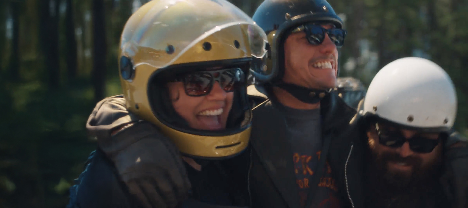 3 riders wearing helmets laughing