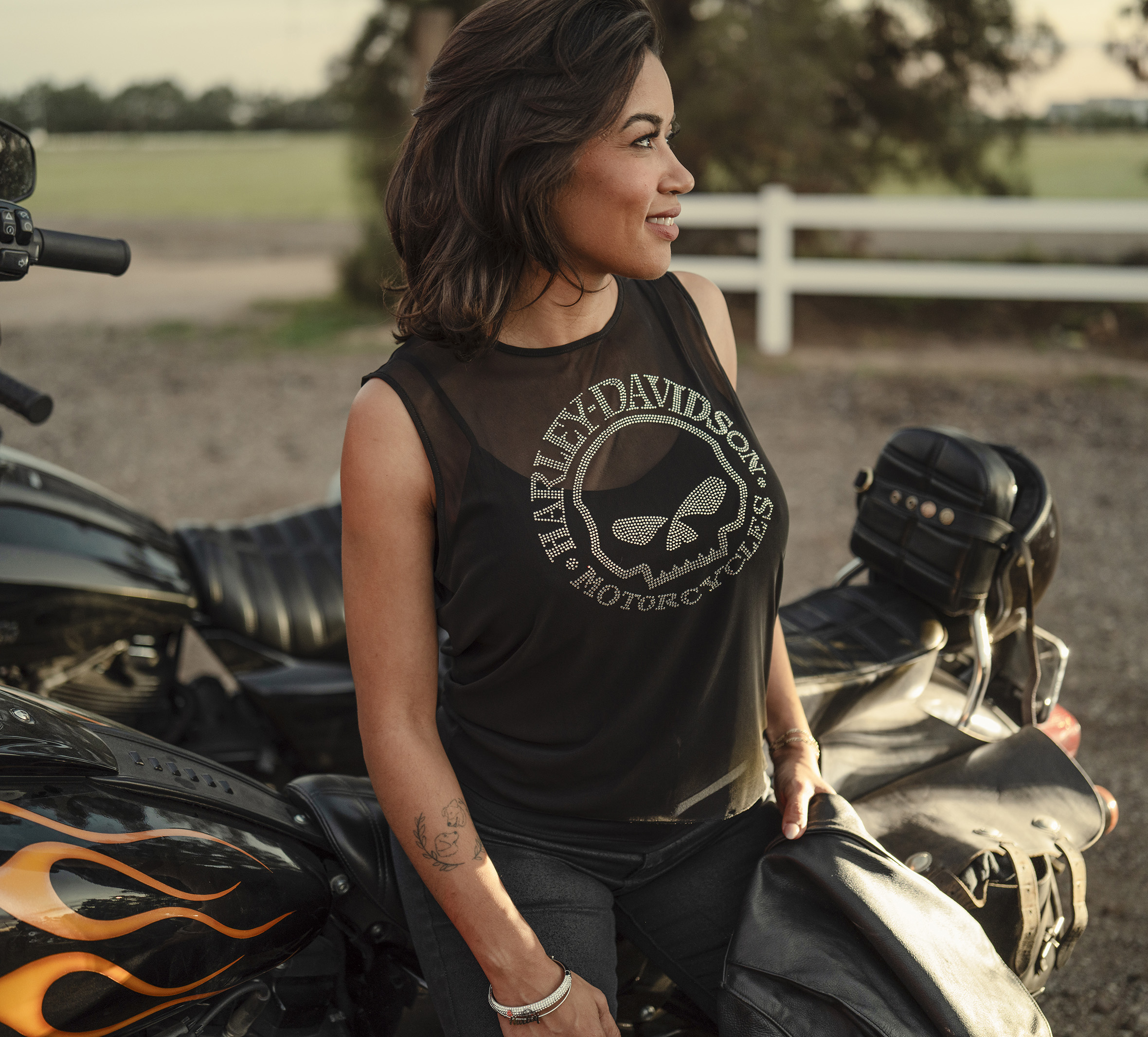 woman wearing black willie g skull tank next to motorcycle