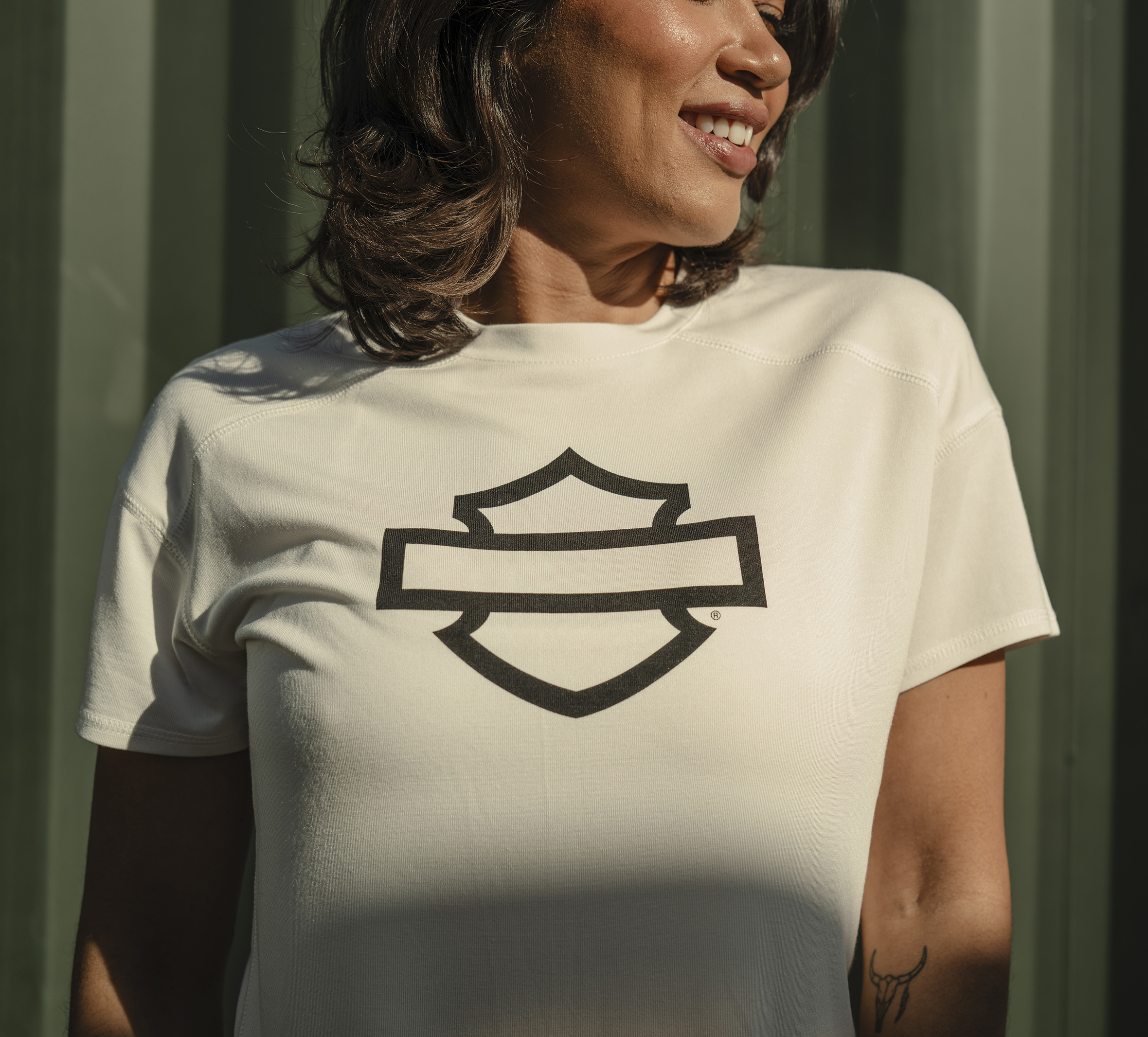 woman wearing white tshirt with bar & shield logo