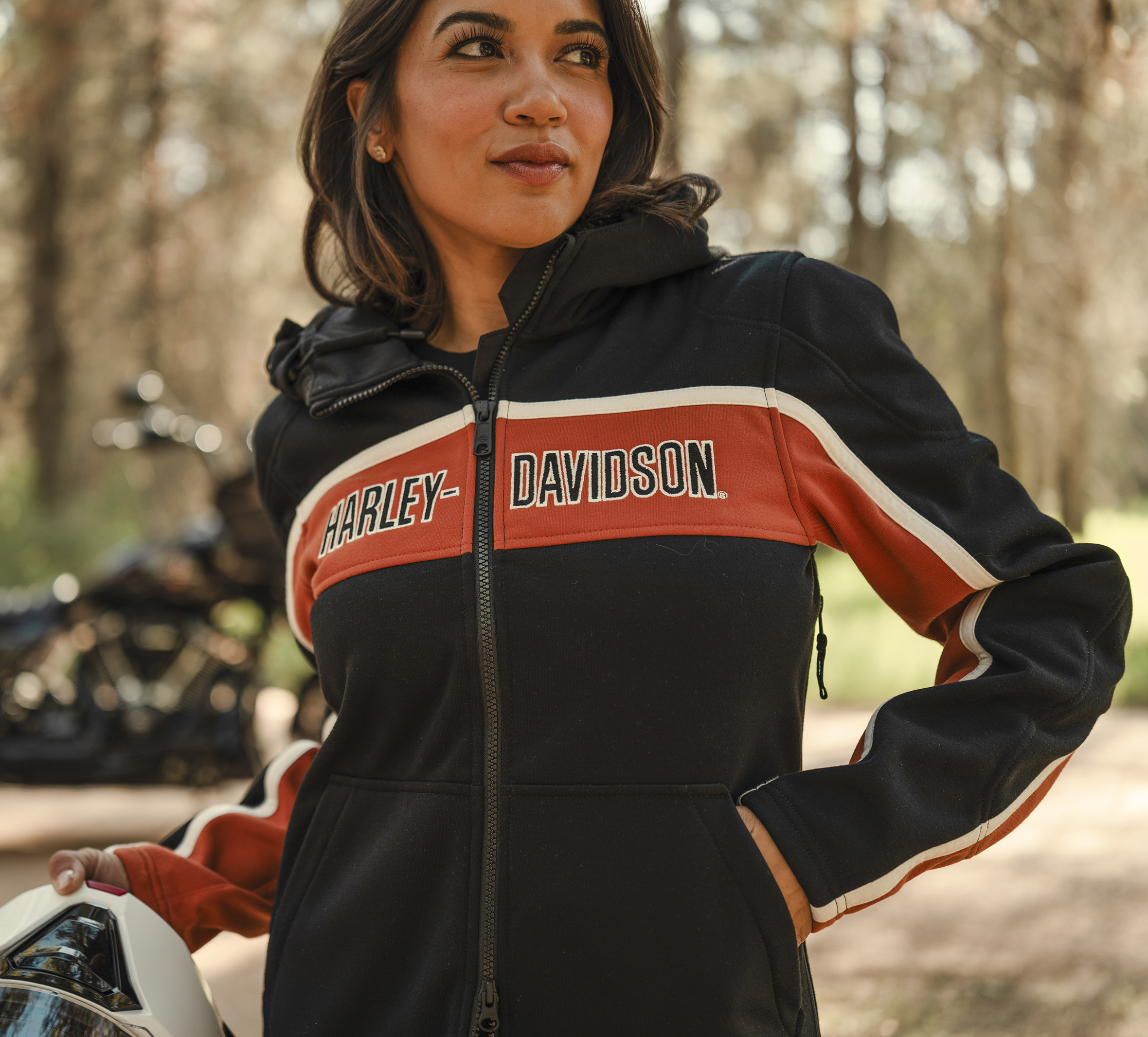 woman wearing black jacket with orange stipe containing Harley-Davidson