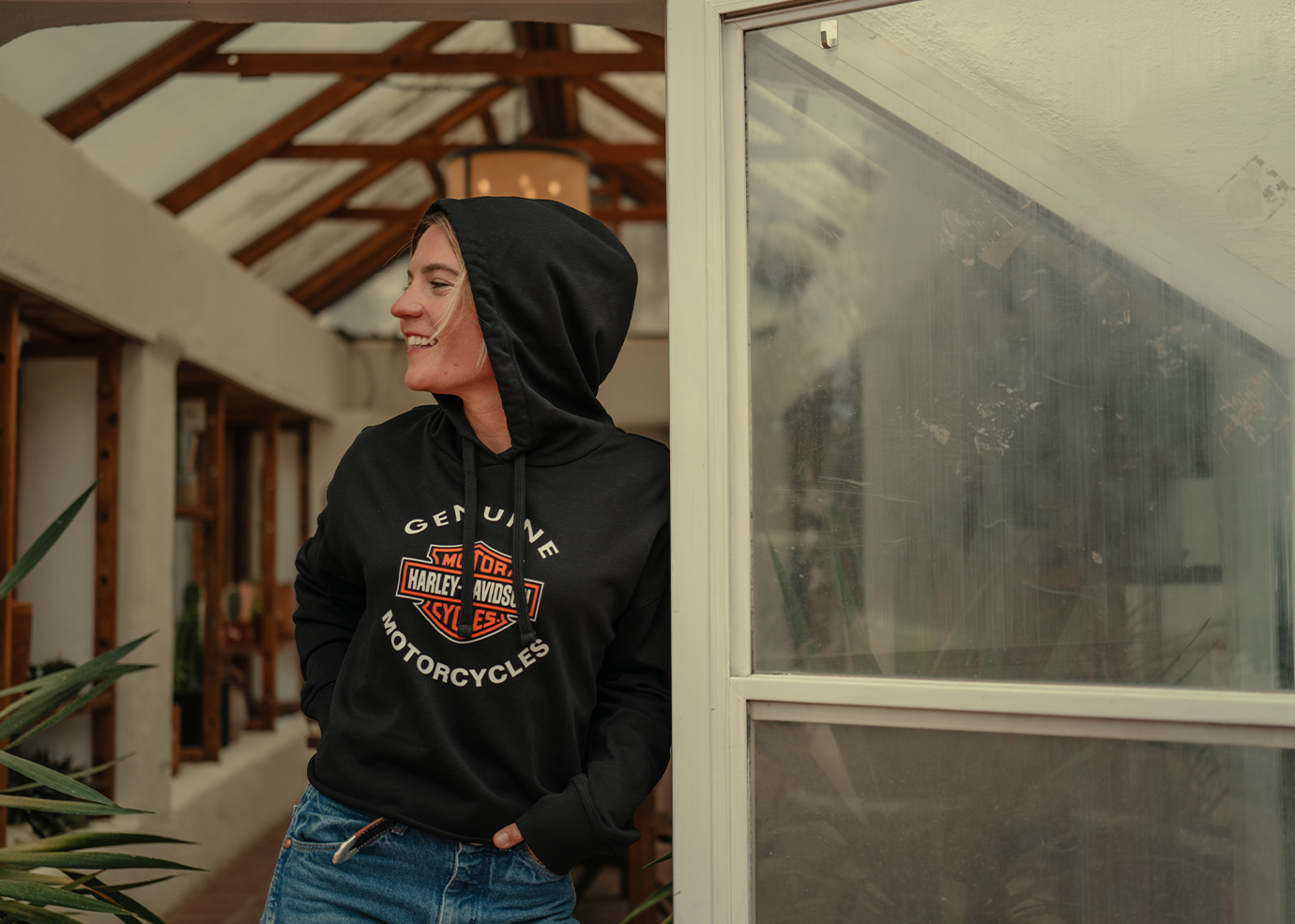 A person wearing a HD hoodie leans against wall